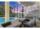 Relaxing screened-in lanai with a pool, spa, comfortable seating, and a fire pit table at 7538 Camden Harbour Dr, Bradenton, FL 34212