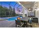 Covered pool patio featuring a pool, jacuzzi, dining table, and comfortable seating at 7538 Camden Harbour Dr, Bradenton, FL 34212