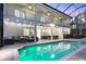 A covered patio, dining area, and outdoor seating surround a pool and hot tub at 7538 Camden Harbour Dr, Bradenton, FL 34212