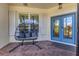 Inviting front porch featuring a hanging chair, shuttered windows, and a bright blue front door at 7538 Camden Harbour Dr, Bradenton, FL 34212