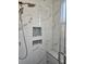 Marble shower with a built-in bench, a handheld showerhead, and two built-in niches at 7538 Camden Harbour Dr, Bradenton, FL 34212