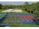 Shuffleboard and cornhole area with green grass, landscaping, benches, and shade at 7538 Camden Harbour Dr, Bradenton, FL 34212