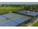 Aerial view of community tennis courts with nets and green landscaping near pond at 7538 Camden Harbour Dr, Bradenton, FL 34212