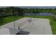 Aerial view of community sand volleyball courts with shade and green landscaping near a pond at 7538 Camden Harbour Dr, Bradenton, FL 34212