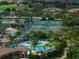 Stunning aerial view of tennis courts, pool, and surrounding lush landscape at 7803 Grand Estuary Trl # 102, Bradenton, FL 34212