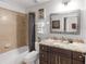 Full bathroom featuring granite counters, patterned mirror and tub with shower at 7803 Grand Estuary Trl # 102, Bradenton, FL 34212