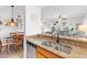 Open-concept kitchen featuring granite countertops, stainless steel sink, and a breakfast bar overlooking the dining area at 7803 Grand Estuary Trl # 102, Bradenton, FL 34212