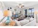 Bright living room with stylish furnishings, fan, and a slider leading to a screened lanai with lake views at 7803 Grand Estuary Trl # 102, Bradenton, FL 34212
