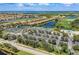 A breathtaking aerial view of tennis courts and residential area with beautiful landscaping and water features at 8304 Grand Estuary Trl # 104, Bradenton, FL 34212