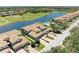 An aerial view highlights a home with a pool and water view near a golf course at 8304 Grand Estuary Trl # 104, Bradenton, FL 34212