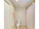 Bright bathroom with a toilet, tiled floors, and a shower/tub combo with a stylish, patterned shower curtain at 8304 Grand Estuary Trl # 104, Bradenton, FL 34212