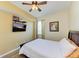 Cozy bedroom with a ceiling fan, TV, and a comfortable bed with a white comforter, creating a relaxing retreat at 8304 Grand Estuary Trl # 104, Bradenton, FL 34212