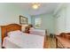 Inviting bedroom with two twin beds, wood floors, ceiling fan, and a bright window at 8304 Grand Estuary Trl # 104, Bradenton, FL 34212