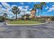 Landscaped entrance to clubhouse featuring lush greenery and mature palm trees at 8304 Grand Estuary Trl # 104, Bradenton, FL 34212