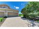 Charming home with a brick driveway, manicured lawn, and attached garage at 8304 Grand Estuary Trl # 104, Bradenton, FL 34212