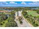Aerial view of a gated entrance with lush landscaping, mature trees, and water features at 8304 Grand Estuary Trl # 104, Bradenton, FL 34212