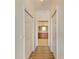 Hallway leading to a bathroom featuring wood-look flooring and a neutral color palette at 8304 Grand Estuary Trl # 104, Bradenton, FL 34212