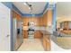 Well-lit kitchen featuring wood cabinets, stainless steel appliances, and granite countertops at 8304 Grand Estuary Trl # 104, Bradenton, FL 34212