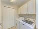Convenient laundry room featuring a modern washer and dryer set, ample storage cabinets, and a closet for organized living at 8304 Grand Estuary Trl # 104, Bradenton, FL 34212