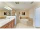 Spacious main bathroom with a soaking tub, glass shower, and double vanity with ample counter space at 8304 Grand Estuary Trl # 104, Bradenton, FL 34212
