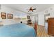 Comfortable main bedroom featuring a wood bed frame, desk, ceiling fan, and bright windows at 8304 Grand Estuary Trl # 104, Bradenton, FL 34212