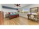 Spacious main bedroom with wood floors, bright windows, a desk, a ceiling fan, and a blue accent wall at 8304 Grand Estuary Trl # 104, Bradenton, FL 34212