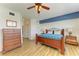 Spacious main bedroom with a wood bed frame, matching furniture, light wood flooring, and ceiling fan at 8304 Grand Estuary Trl # 104, Bradenton, FL 34212