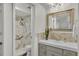Stylish bathroom featuring modern sink, marble-look accent wall, and walk-in shower with gold accents at 9430 Glen Moor Ln, Port Richey, FL 34668