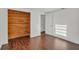 Bedroom with wood floors, closet, and a well-lit door with minimalist design at 9430 Glen Moor Ln, Port Richey, FL 34668