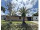 Charming single-story home featuring stucco siding, a garage, a well-maintained lawn, and mature trees at 9430 Glen Moor Ln, Port Richey, FL 34668