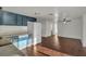 Open layout showcasing kitchen with blue cabinetry, white appliances, and wood floors, seamlessly connecting to living area at 9430 Glen Moor Ln, Port Richey, FL 34668