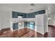 Bright kitchen features blue cabinets, white appliances, and hardwood floors at 9430 Glen Moor Ln, Port Richey, FL 34668