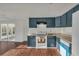 Stylish kitchen featuring blue cabinetry, white appliances, and wood floors, open to sunroom at 9430 Glen Moor Ln, Port Richey, FL 34668