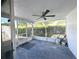 Screened lanai features a ceiling fan, neutral tones, and ample space for relaxing and entertaining at 9430 Glen Moor Ln, Port Richey, FL 34668