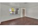 Bright living room with white walls, wood floors, and natural light from a large window at 9430 Glen Moor Ln, Port Richey, FL 34668