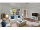 Bright living room with white sofa, blue accents, and a large window offering natural light at 9430 Glen Moor Ln, Port Richey, FL 34668