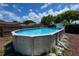 Backyard featuring an above-ground swimming pool surrounded by a well-maintained fence, perfect for summer fun at 9430 Glen Moor Ln, Port Richey, FL 34668