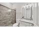Bathroom featuring a walk-in shower, toilet, granite countertop, and decorative mirror and lights at 7036 Highgate Ln, Lakewood Ranch, FL 34202