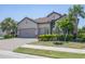 Well-manicured lawn and colorful shrubs add curb appeal to this single Gathering home with a brick driveway at 7036 Highgate Ln, Lakewood Ranch, FL 34202