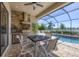 Outdoor kitchen featuring a built-in grill, stone accents, a ceiling fan and seating for four at 7036 Highgate Ln, Lakewood Ranch, FL 34202