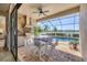Beautiful outdoor kitchen and dining area overlooking the pool, lake and outdoor seating area at 7036 Highgate Ln, Lakewood Ranch, FL 34202