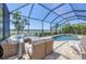 Inviting outdoor seating area with comfortable wicker furniture, overlooking a pool, spa, and lake view at 7036 Highgate Ln, Lakewood Ranch, FL 34202