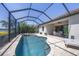 Sparkling swimming pool with screened-in enclosure and jacuzzi, surrounded by well-manicured landscaping at 7036 Highgate Ln, Lakewood Ranch, FL 34202