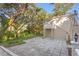 Back of the house with a stone-paved patio and lush trees, a private outdoor space at 1577 Alexander Rd, Belleair, FL 33756