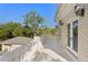 Balcony with white stone railing, French doors offering outdoor access and views of lush landscape at 1577 Alexander Rd, Belleair, FL 33756
