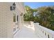 Private balcony features a white stone railing, french doors and views of mature trees at 1577 Alexander Rd, Belleair, FL 33756