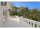 Private balcony offers white stone railings, and views of lush greenery for serene outdoor enjoyment at 1577 Alexander Rd, Belleair, FL 33756