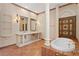 Lavish bathroom features dual sinks, stone accents, decorative columns, and a luxurious soaking tub at 1577 Alexander Rd, Belleair, FL 33756