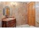 Elegant bathroom with a custom vanity, marble tile, and ornate chandelier at 1577 Alexander Rd, Belleair, FL 33756