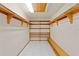 Bright closet featuring tile floors, multiple shelves, wood trim and a bright light at 1577 Alexander Rd, Belleair, FL 33756